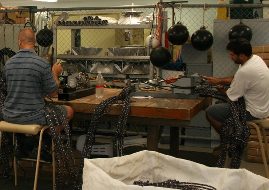 Workjers mending and creating ropes for pearl farm