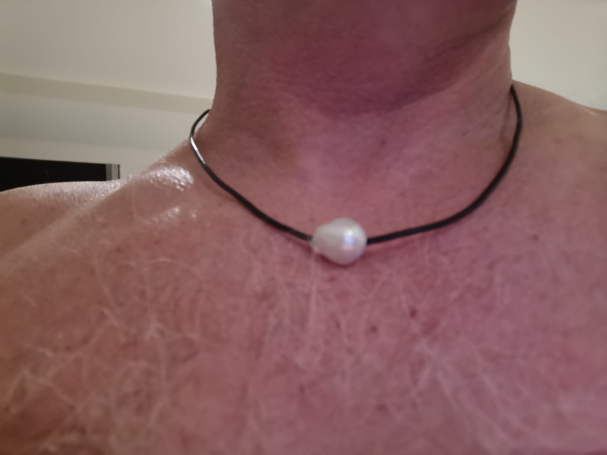 bright white pearl on a black leather thong bought again from Pearlescence