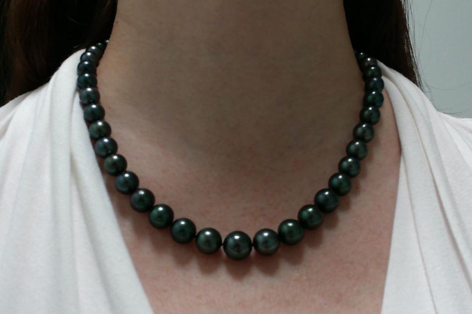 the Tahitian pearls are deep blue, with hints of green and purple and high luster