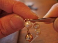 Stringing tutorial 16- Guide the closest part of the knot loop between the pearl and the tweezer.jpg