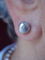 ear shot of baroque silver blue akoya stud earrings; you can see some orient