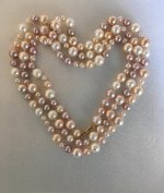 Cultured freshwater pearl rope in various sizes and colors laid in heart shape 