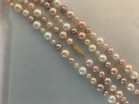 Cultured freshwater pearl rope in various sizes and colors laid our in four row