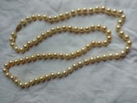 pearls on white 32 with 8.5-9 mm pearls of yellowish cream color, moderate blemishes and medium luster