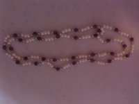 All pearls are fresh waters of various shapes. Red and gold ones are dyed. Peach and mauve ones are natural color I think, no visible evidence of dyeing at the holes or in ant of the pits and other imperfections on the pearls where dye tends to collect. Amethyst, garnet, and black onyx beads were also used