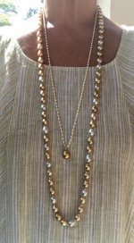 wearing white and gold south sea strand with golden pearl pendant with dress close up