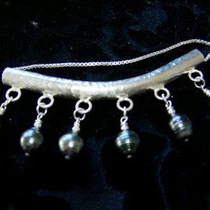 6 peacock tahitian pearls hanging from a heavy hammered Hill Tribe Silver bar pendant.  Probably my favorite piece.  Should have never sold it!