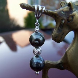 Here are two Tahitian pearls drilled against the circles (weird, huh?) on a pendant with sterling silver bail and circle etched accent bead.