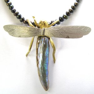 dragonfly with one large free form natural abalone pearl. The wings are made of 18ct yellow gold.