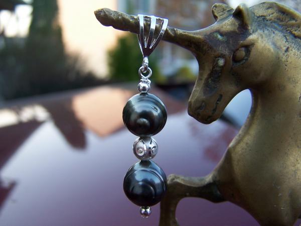 Here are two Tahitian pearls drilled against the circles (weird, huh?) on a pendant with sterling silver bail and circle etched accent bead.